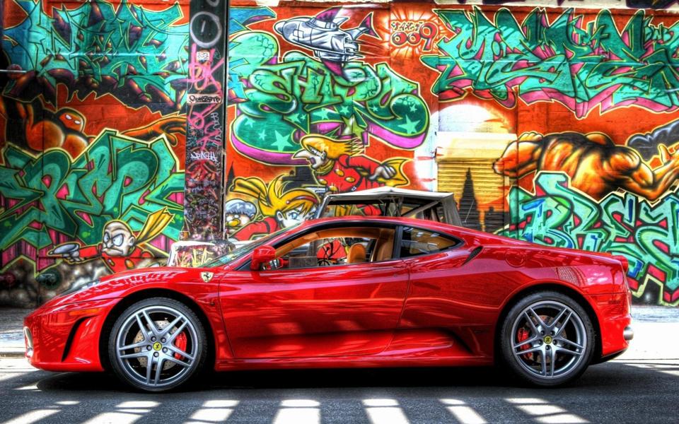 涂鸦墙前的红色法拉利超级跑车