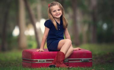 坐在行李箱上的可爱小女孩高清儿童壁纸